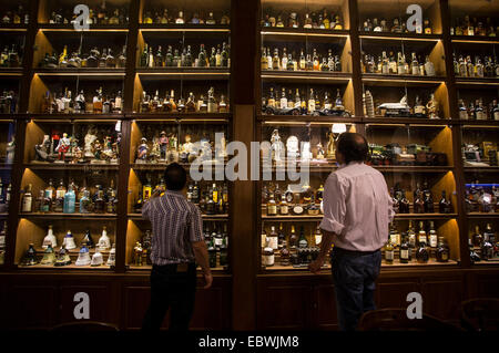 Buenos Aires, Argentine. 9Th Jul 2014. Les visiteurs observer bouteilles exposées au Musée du whisky à Buenos Aires, capitale de l'Argentine, le 4 décembre 2014. Le Musée du whisky a été ouverte le 10 novembre, et montre plus de trois mille bouteilles des meilleurs whiskies du monde. En plus de la collection exposée en permanence, le musée possède des chambres et des salles thématiques où les activités pour les membres du club "Whisky malt Argentina' ont lieu, apportant une nouvelle attraction touristique et culturel de la ville de Buenos Aires. © Martin Zabala/Xinhua/Alamy Live News Banque D'Images