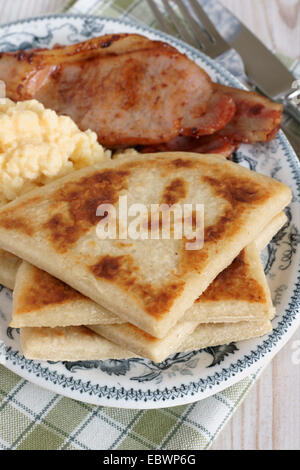 Pomme de terre farls de pommes de terre ou les gâteaux avec du bacon et des œufs brouillés Banque D'Images