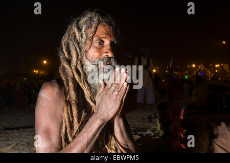 Shiva sadhu, saint homme, assis et en priant la nuit au Sangam, le confluent des fleuves Ganges, Yamuna et Saraswati Banque D'Images