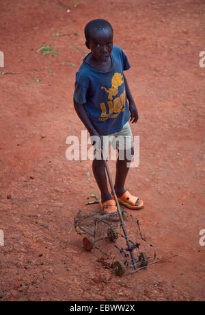 Garçon jouant avec selfmade wire frame petite voiture Gitega, Burundi, Banque D'Images