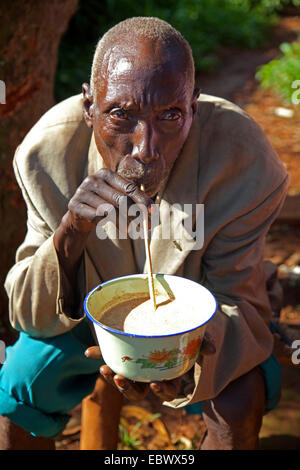 Man drinking beer traditionnels de bananes 'pombe' avec paille, Burundi, Cankuzo, Cankuzo Banque D'Images