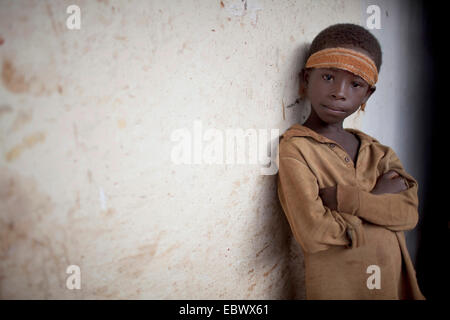 Portrait d'un jeune garçon appuyé contre un mur de la maison dans un village de pêcheurs, au Burundi, Nyanza-lac, Mvugo, Nyanza Lac Banque D'Images