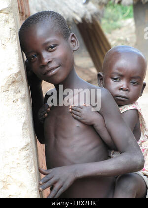 Deux petits enfants dans le camp de réfugiés pour les personnes déplacées dans le nord de l'Ouganda autour de Gulu, simple maison de terre en arrière-plan, l'Ouganda, Gulu Banque D'Images