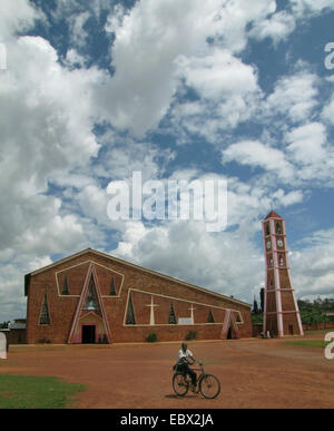 Jeune homme monté sur un vélo en face d'une grande église moderne, du Burundi, Gitega, Gitega Banque D'Images