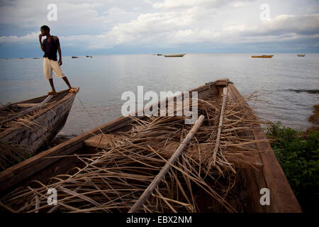 Garçon debout sur le bateau de pêche au lac Tanganyika, au Burundi, de Makamba Banque D'Images