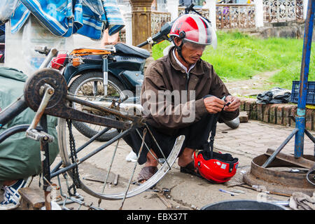 Réparation de bicyclettes des travailleurs vietnamiens au marché local. Banque D'Images