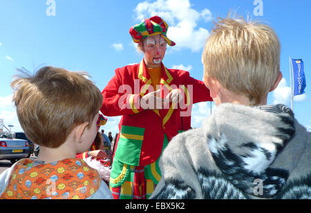 Vêtus de couleurs clown rue plaisanter, les enfants le regarder, Pays-Bas, Noordwijk Banque D'Images