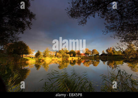 Soleil qui brille sur une rive du lac par un trou dans la couverture nuageuse, l'ALLEMAGNE, Basse-Saxe, Vogtlaendische Schweiz, Neuastenberg Banque D'Images