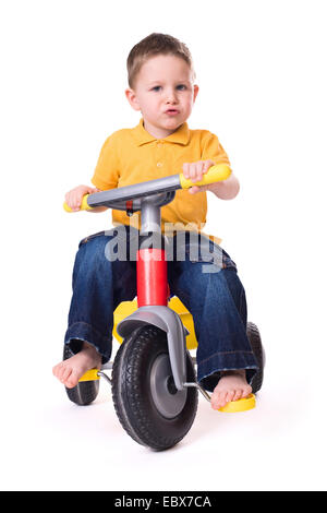 Cute little boy riding un vélo à 3 roues Banque D'Images