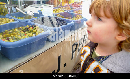 Petit garçon en face d'un stand du marché aux olives, Espagne, Baléares, Majorque, Alcudia Banque D'Images