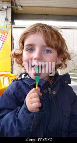 Petit garçon avec une langue verte et un green lolly Banque D'Images