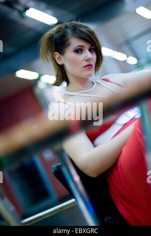 Jolie brunette woman in a red, assis Banque D'Images