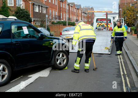 Une voiture d'être saisi et remorqué dans un milieu urbain uk street Banque D'Images