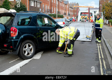 Une voiture d'être saisi et remorqué dans un milieu urbain uk street Banque D'Images