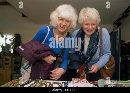 Deux dames âgées parcourant les bijoux décroche à une piscine Marché de Noël, près de Alton, Hampshire, Royaume-Uni. Banque D'Images