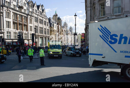 Un london ambulance est aidé par le trafic par la police près de Trafalgar Square Banque D'Images