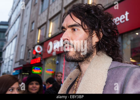 Oxford Street, Londres, Royaume-Uni. 5 Décembre, 2014. L'acteur et activiste politique s Comdeian Russel Brand visites de plusieurs grandes marques de bord y compris les bottes, Apple et Vodafone à Londres les accusant d'impôt tout en évitant ceux qui en ont le plus besoin de prestations sont confrontés à des coupures et des difficultés accrues. Un dépliant distribué par lui prétend €14 milliards est perdu chaque année, grâce à l'évitement fiscal et les échappatoires exploitées par les grandes entreprises. Sur la photo : Russel marque en dehors de la direction de Vodafone d'Oxford Street. Crédit : Paul Davey/Alamy Live News Banque D'Images