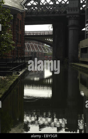 Réflexions de l'eau quai de pommes de terre portrait vers le nord du grand viaduc et Pont des Marchands, le Castlefield bassin du Canal, Manchester Banque D'Images