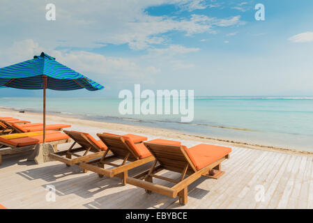 De nombreuses chaises longues avec parasols à la plage sur l'océan Banque D'Images