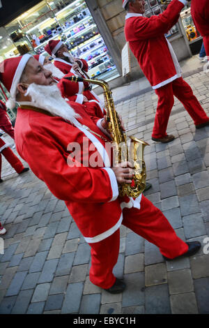 Gibraltar. 5 Décembre, 2014. Gibraltar aujourd'hui vu une longue ligne de Santas se rassemblent à Casemates avant de partir à la rue principale dans une danse Conga. Les clients du soir ont été traités à la danse comme ils Santa conga dirigée à la place avant de se retourner à nouveau de casemates. L'événement faisait partie d'un organisme de bienfaisance exécuter organisé par le Rotary Club, et aidé par la bande de Calpe. Crédit : Stephen Ignacio/Alamy Live News Banque D'Images