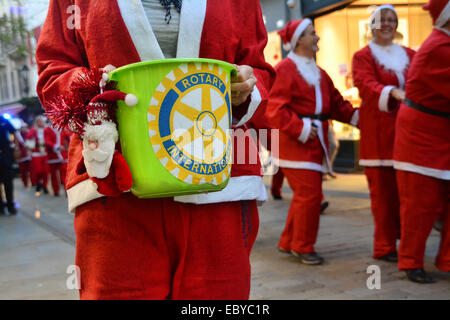 Gibraltar. 5 Décembre, 2014. Gibraltar aujourd'hui vu une longue ligne de Santas se rassemblent à Casemates avant de partir à la rue principale dans une danse Conga. Les clients du soir ont été traités à la danse comme ils Santa conga dirigée à la place avant de se retourner à nouveau de casemates. L'événement faisait partie d'un organisme de bienfaisance exécuter organisé par le Rotary Club, et aidé par la bande de Calpe. Crédit : Stephen Ignacio/Alamy Live News Banque D'Images