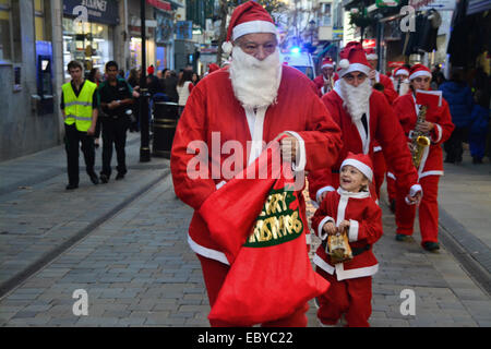 Gibraltar. 5 Décembre, 2014. Gibraltar aujourd'hui vu une longue ligne de Santas se rassemblent à Casemates avant de partir à la rue principale dans une danse Conga. Les clients du soir ont été traités à la danse comme ils Santa conga dirigée à la place avant de se retourner à nouveau de casemates. L'événement faisait partie d'un organisme de bienfaisance exécuter organisé par le Rotary Club, et aidé par la bande de Calpe. Crédit : Stephen Ignacio/Alamy Live News Banque D'Images