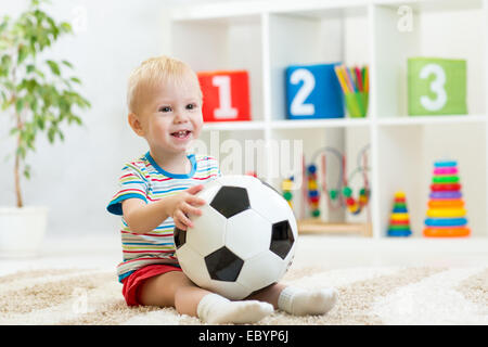 Kid boy avec football indoor Banque D'Images