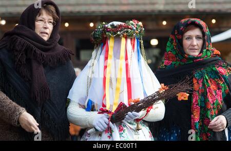 Lehde, Allemagne. 6e déc, 2014. Ce qu'on appelle présent donner enfant (C), une vieille coutume pré-Noël de la Lausitz, et ses compagnons de marche le long de la foire de Noël dans le musée en plein air Lehde, Allemagne, 6 décembre 2014. Les visiteurs peuvent assister à la foire avec un bateau et apprendre beaucoup sur les traditions et coutumes des habitants de la forêt de la Spree. Photo : Patrick Pleul/dpa/Alamy Live News Banque D'Images