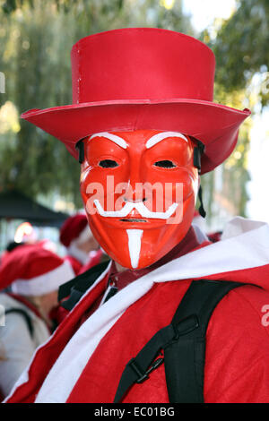 Londres, Royaume-Uni. 6 décembre 2014. Participant portant un masque anonyme habillé en père Noël dans le Londres 2014 Santacon dans les rues de Londres qui célèbre sa 20e année anniversdary ce crédit : Paul Brown/Alamy Live News Banque D'Images