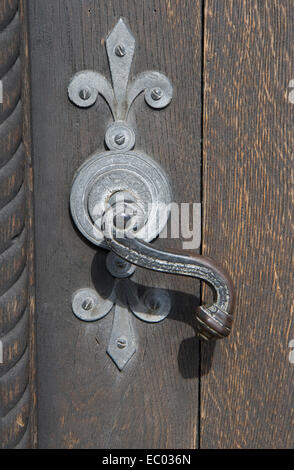 Poignée de porte avec fleur de lys sur une porte de l'église Banque D'Images