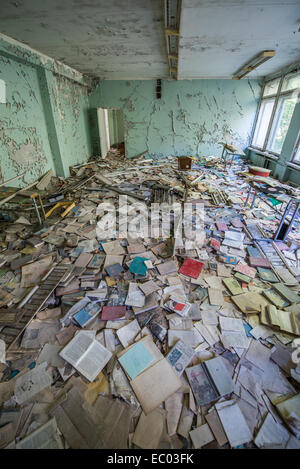 Beaucoup de livres dans la salle de classe de l'école intermédiaire numéro 3 dans la ville abandonnée Pripyat, zone d'exclusion de Tchernobyl, l'Ukraine Banque D'Images