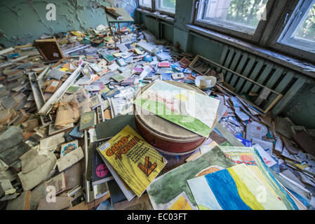 Beaucoup de livres et de dessins dans la salle de classe de l'école intermédiaire numéro 3 dans la ville abandonnée Pripyat, zone d'exclusion de Tchernobyl, l'Ukraine Banque D'Images