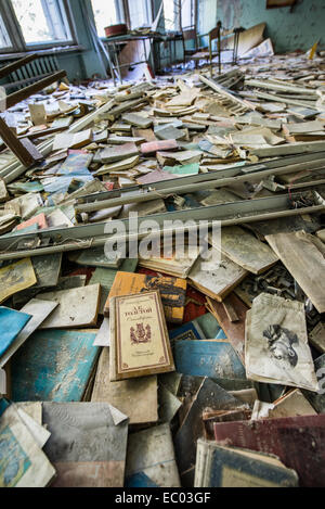 Beaucoup de livres dans la salle de classe de l'école intermédiaire numéro 3 dans la ville abandonnée Pripyat, zone d'exclusion de Tchernobyl, l'Ukraine Banque D'Images