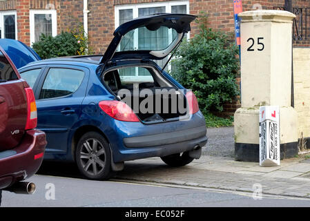 Voiture auto-école avec le capot ouvert stationne illégalement sur double lignes jaunes Banque D'Images