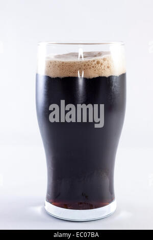 Pinte de stout en verre sur un fond blanc. Banque D'Images