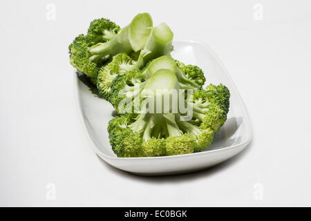 Fresh Brocoli (Brassica oleracea italica) groupe dans une assiette blanche sur fond blanc Banque D'Images