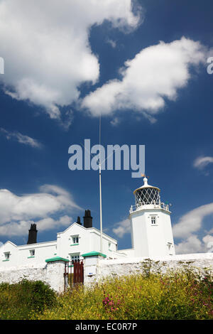 Un phare peint en blanc avec des chalets. Banque D'Images