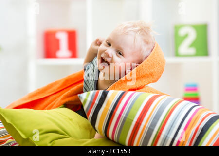 Kid Garçon jouant sur des coussins dans la chambre Banque D'Images