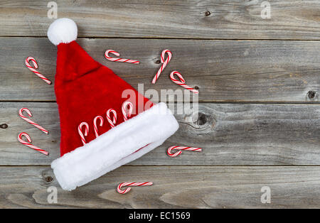 Top View close up de cannes de bonbon et Santa hat mis sur bois rustique Banque D'Images