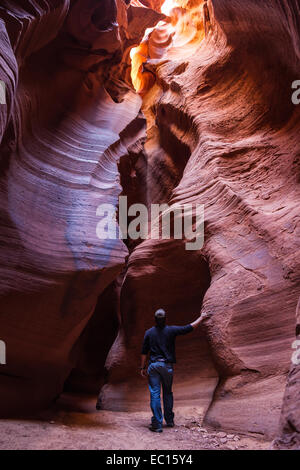 Jeune homme à la découverte de canyons logement Page en Arizona avec de belles nuances de rouge et d'orange Banque D'Images