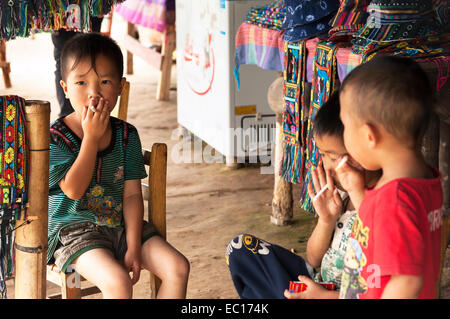 Les jeunes garçons chinois prétendant à fumer avec des bonbons bâtonnets dans la province de Guangxi, Chine Banque D'Images