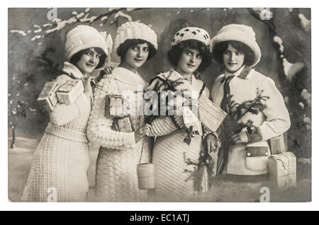 Heureux les jeunes femmes avec des cadeaux et l'arbre de Noël. vintage Photo avec grain de film original et flou Banque D'Images