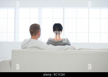 Young caucasian couple sitting on sofa in new house Banque D'Images