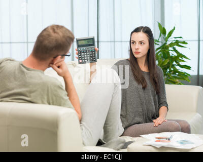 Young caucasian couple faisant leurs comptes à la maison Banque D'Images