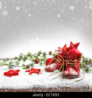 Décoration de Noël nostalgique avec des chaussures de bébé. retro photo avec effet de chute de neige Banque D'Images