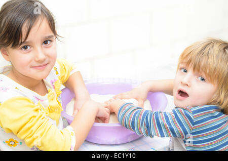 Sweet Enfants jouant dans la cuisine Banque D'Images