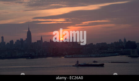 Soleil se lève sur l'île de Manhattan, silhouetting, comme le trajet bateaux Hudson. Banque D'Images