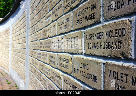 Un mur de briques avec des mots gravés sur eux. Banque D'Images