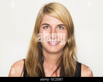 Jeune femme qui a l'air dans l'appareil photo avec de longs cheveux raides, portrait Banque D'Images