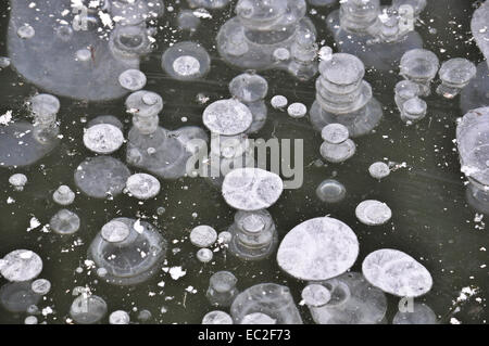 La texture de la première glace. Des bulles d'air dans la glace à la fin de l'automne sur l'étang. Banque D'Images
